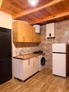a kitchen with a white refrigerator and a dishwasher at Alpase Resort in Didi Khalebi