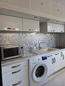 a kitchen with a washing machine and a microwave at Flamboyant Studio avec Piscine et Parking in Saint Martin