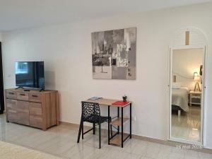 a room with a table and a mirror and a bedroom at Flamboyant Studio avec Piscine et Parking in Saint Martin