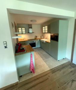 a kitchen with green cabinets and a red and white object at Maison Campagnard in Voeren