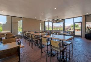 a restaurant with tables and chairs and large windows at Arabella Hotel Sedona in Sedona