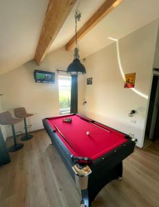 a pool table in a room with a red pool at Maison Campagnard in Voeren