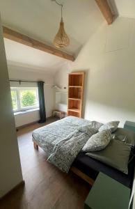 a bedroom with a bed and a window at Maison Campagnard in Voeren