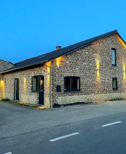 a brick building on the side of a street at Maison Campagnard in Voeren