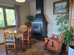 a living room with a table and a stove at Setcases-Vallter hostal Mitja Pensió 3 in Setcases
