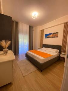 a bedroom with a large bed with an orange blanket at Perla Blu House in La Spezia