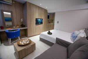 um quarto de hotel com uma cama e um sofá em Sounio Sea View em Sounio