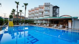 a large swimming pool in front of a building at Side Özgürhan Hotel in Side