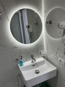 a white bathroom with a sink and a mirror at Dream Seaview Apartment INI in Íshulli i Tetranisit +28 photos