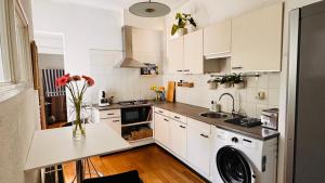 a kitchen with white cabinets and a washer at Light and Spacious Getaway House in Arnhem +10 photos