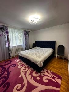 a bedroom with a bed and a purple rug at Guest House Sveta in Saty