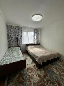 a bedroom with two beds and a window at Guest House Sveta in Saty