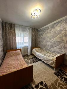 a bedroom with two beds and a wall mural at Guest House Sveta in Saty