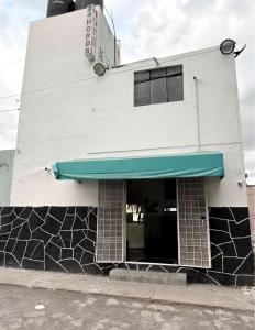 a white building with a blue awning on it at Los Olivos in Atlixco