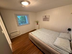 a bedroom with a bed and a window at Sukkertoppen Apartment in Ålesund