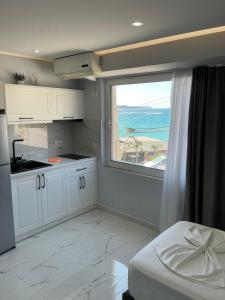 a white kitchen with a large window and a bed at Dream Seaview Apartment INI in Íshulli i Tetranisit