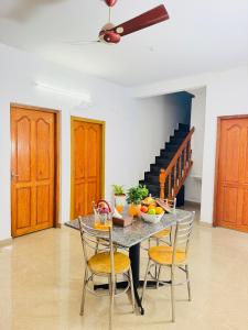 a kitchen with a table and chairs with fruit on it at Mist & Meadows Premium VIlla By STAYVA in Munnar +27 photos