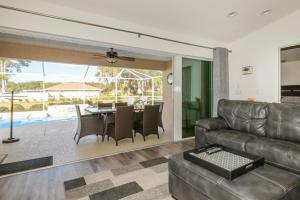 a living room with a leather couch and a table at Withlacoochee Trail Getaway - Private Pool - 3bedrooms in Inverness