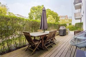 a wooden table with chairs and an umbrella on a deck at Helenas place in Berlin