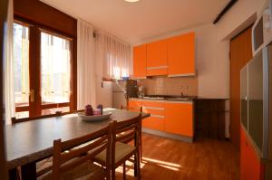 a kitchen with orange cabinets and a table and chairs at Appartamenti Splendid E Salisburgo in Bibione