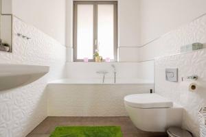 a white bathroom with a toilet and a bath tub at Helenas place in Berlin +24 photos