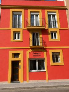 a red and yellow building with windows and balconies at Port Apartsuite in Tarragona