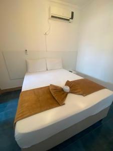a white bed with a brown blanket on it at Santa Ana da Ribeira in SantʼAnna do Ipanema +2 photos