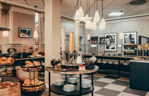 a bakery with two tables with food on it at Leonardo Hotel Köln in Cologne +31 photos