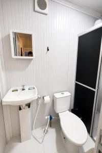 a white bathroom with a toilet and a sink at Pousada Villa Sítio in Campina Grande +23 photos