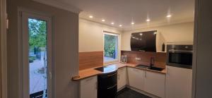 a kitchen with white cabinets and a sink and a window at Lavendelhaus am Müritzsee - direkt am Wasser in Buchholz
