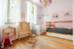 a bedroom with pink walls and a bed and a chandelier at Helenas place in Berlin