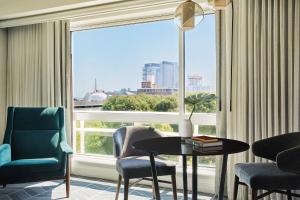 ein Zimmer mit Tisch und Stühlen und einem großen Fenster in der Unterkunft Kimpton Marlowe by IHG in Cambridge