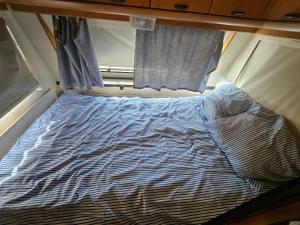 a bed in a small room with a window at Full Service Caravan 3 in Søborg