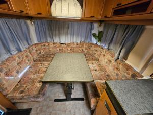a couch in the middle of a room with a table at Full Service Caravan 3 in Søborg