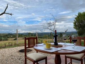 a table with a bottle of wine and two glasses at La cabaña in Sotaquirá