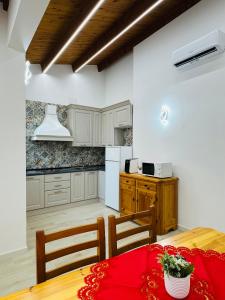 a kitchen with a table with a red table cloth on it at TBS House in Alghero +9 photos