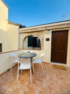 a patio with a table and chairs and a door at TBS House in Alghero