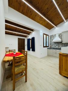 a dining room with a table and a kitchen at TBS House in Alghero