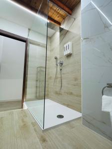 a bathroom with a shower with a glass door at TBS House in Alghero