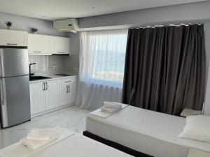 a white kitchen with two beds and a window at Dream Seaview Apartment INI in Íshulli i Tetranisit