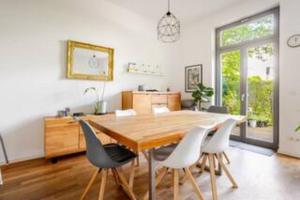 a dining room with a wooden table and chairs at Helenas place in Berlin