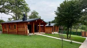a log cabin in a field of grass at Buriani-resort in Tsʼkhvarichamia