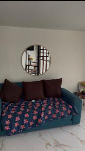 a blue couch in a living room with a mirror at The Jungle Chalet in Cebadilla