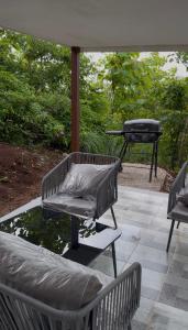 a patio with two benches and a barbecue grill at The Jungle Chalet in Cebadilla
