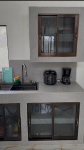 a kitchen with wooden cabinets and a sink and a counter top at The Jungle Chalet in Cebadilla