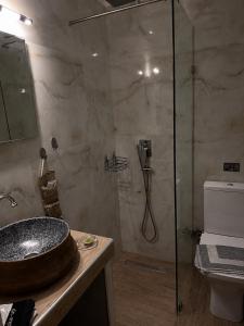 a bathroom with a glass shower with a sink at Kokkala Guestrooms in Kokkala