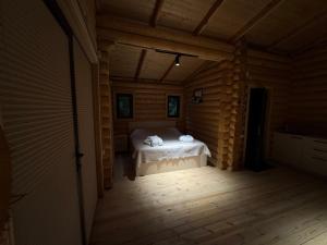a small room with a bed in a log cabin at Buriani-resort in Tsʼkhvarichamia