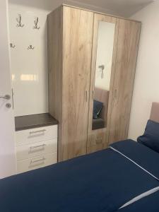 a bedroom with a bed and a cabinet with a mirror at Romantika 4 in Veliko Gradište