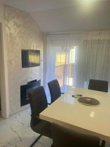 a dining room with a table and chairs and a fireplace at Romantika 4 in Veliko Gradište