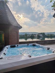 a jacuzzi tub with a view of the water at L'Escale du Rhône de 1 à 8 personnes in Saint-Vallier